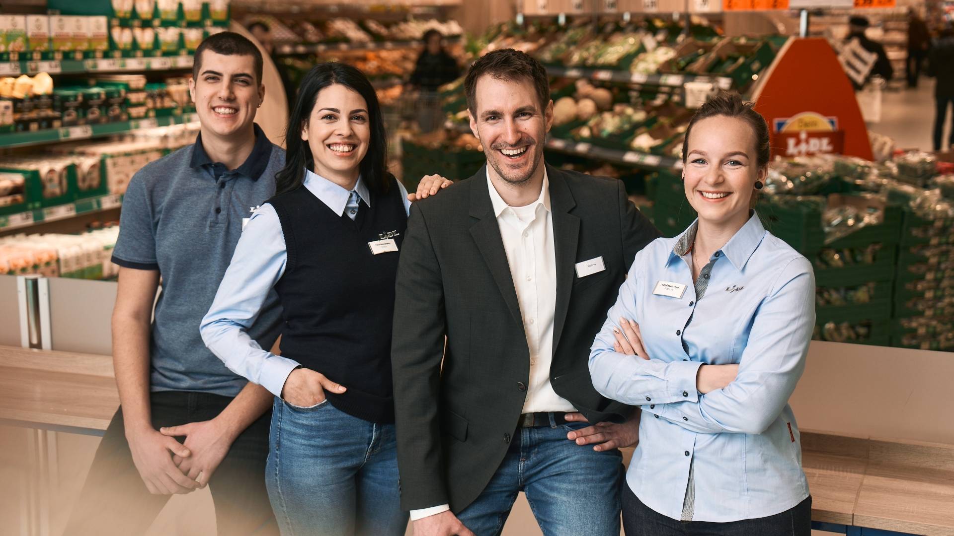 Filialteam steht im Obst- und Gemüsebereich der Filiale