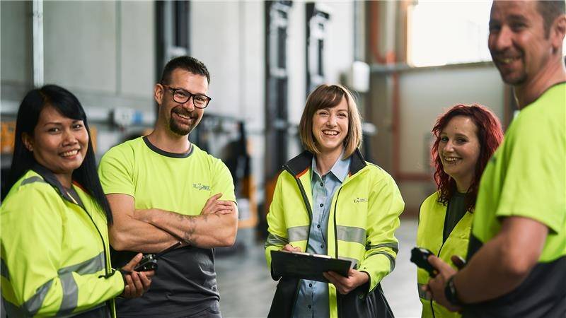 Mehrere Lagermitarbeiter:innen bei der Arbeit